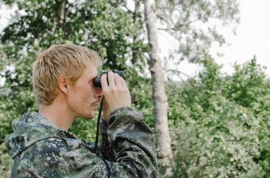 Dürbün mesafe içine bakarak genç turist adam