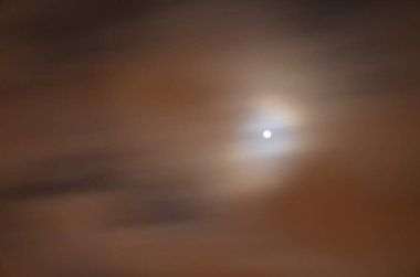 diski dinamik olarak yağlanmış bulutlar arasında gece gökyüzünde parlıyordu