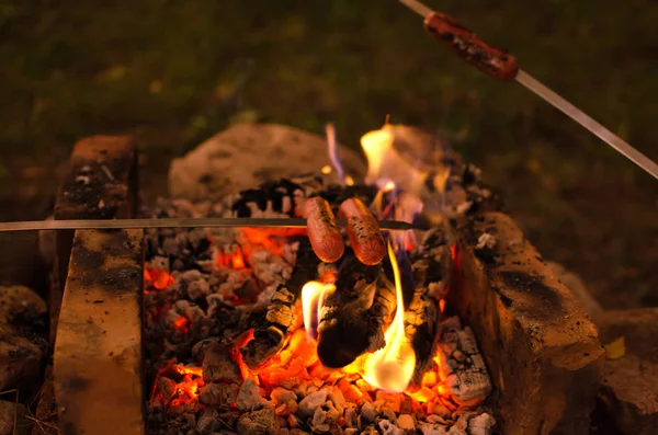 香肠挂在火上烤的烤串上 — 图库照片