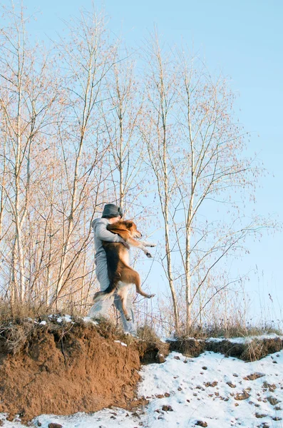 Молодой Человек Несет Собаку Через Непроходимый Зимний Лес — стоковое фото
