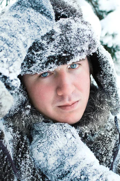 portrait of a blue-eyed Northern man in snow-covered clothes