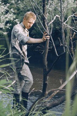 Nehri yakınında ormanda İkinci Dünya Savaşı sırasında eski bir askeri Üniformalı erkeklere