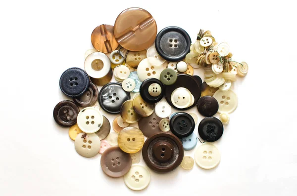 big pile of sewing buttons on light background