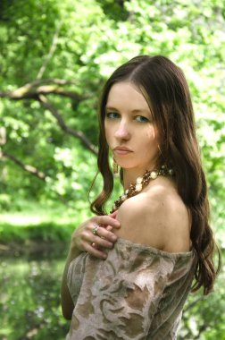 omzunu açığa elbisesini çeker genç esmer güzel bir kadının uzun bir saç modeli ile portresi