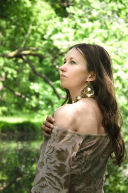 omzunu açığa elbisesini çeker genç esmer güzel bir kadının uzun bir saç modeli ile portresi