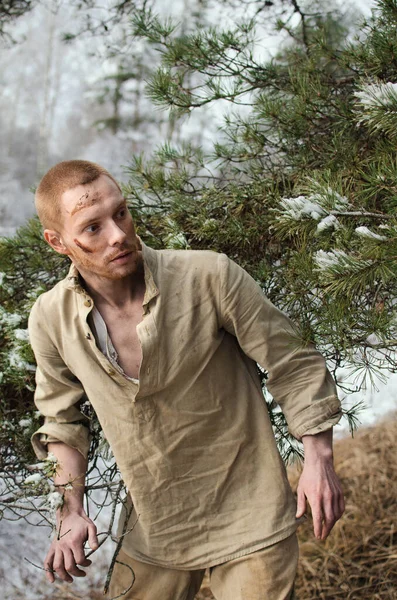 Kış ormanında yüzünde morluklar olan bir asker.