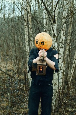 Kafasında balkabağı, ellerinde fenerle Cadılar Bayramı Korkuluğu ormanda kayboldu.