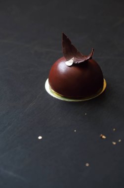 Ptichye Moloko (kuş sütü) - geleneksel Rus vanilya sufle çikolata sır ile kaplı ve siyah arka plan üzerine çikolata eşarplı dekore kek,.