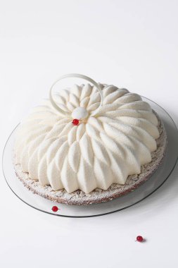 Çağdaş vanilya kırmızı frenk üzümü Mousse kek beyaz arka plan üzerinde beyaz kadife sprey ile kaplı.