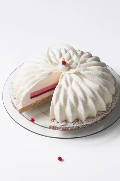 Çağdaş vanilya kırmızı frenk üzümü Mousse kek beyaz arka plan üzerinde beyaz kadife sprey ile kaplı.