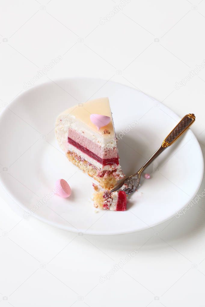 Slice of Contemporary Layered Yogurt Mousse Cake, on white plate, on white background.