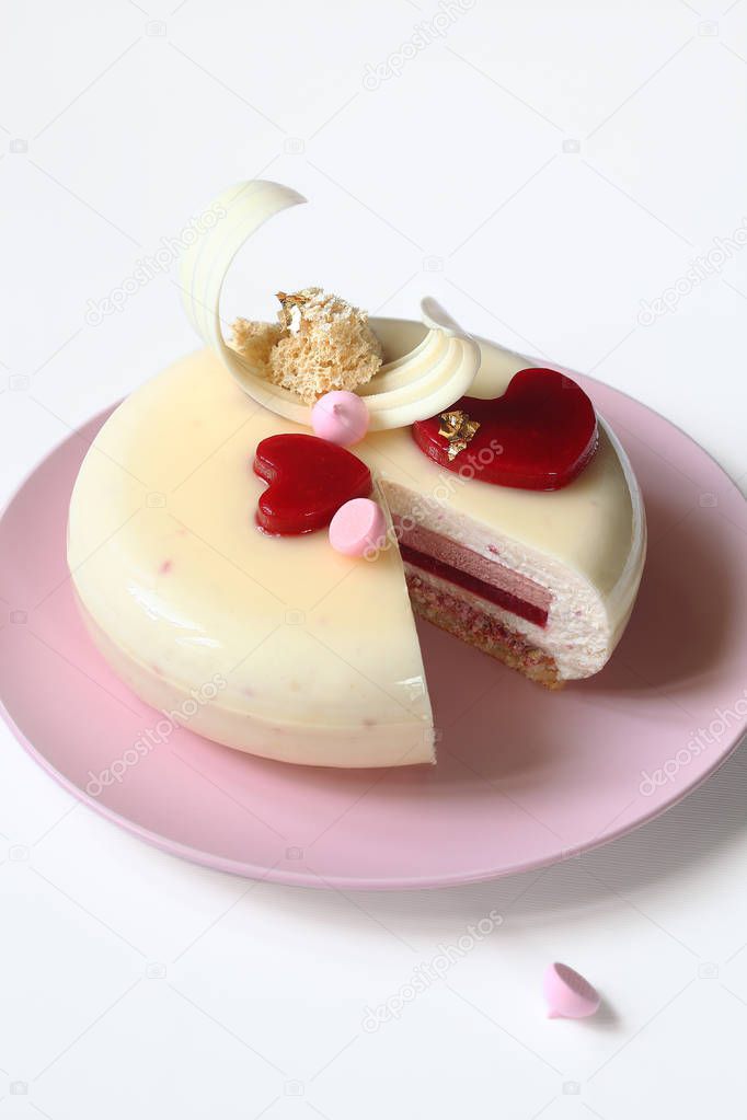 Contemporary Layered Yogurt Mousse Cake decorated with Strawberry Jelly Hearts, on white background.