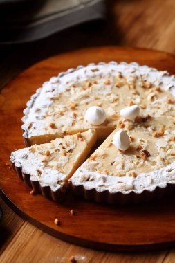 Fındık ve ahşap masa üzerinde kahverengi tabakta beze çerezler ile Çikolatalı limon ekşi.