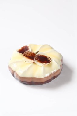 Beyaz arka planda, çikolata yaprakları ile süslenmiş üç çikolata mousse Cake.