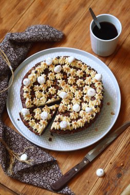 Çikolata brownie kek ile çırpılmış fıstık ezmesi frosting, Meringue kurabiye ile dekore, gri plaka üzerinde, ahşap masa üzerinde.
