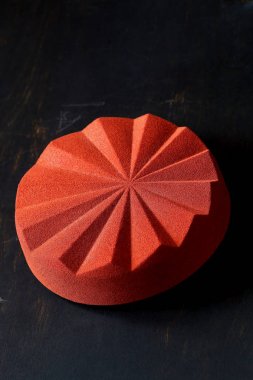 Çağdaş Çikolata Mousse Kek geometrik silikon kalıp yapılmış, tuğla rengi kadife sprey ile kaplı, siyah arka plan üzerinde.