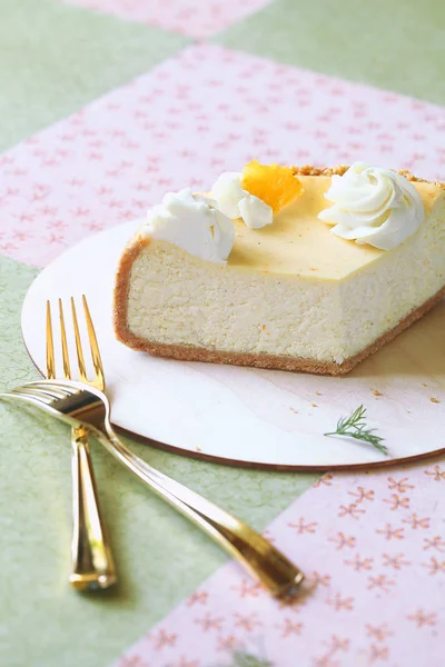 Orangener Käsekuchen Dekoriert Mit Orangenscheiben Und Schlagsahnrosen Auf Einem Holzbrett — Stockfoto