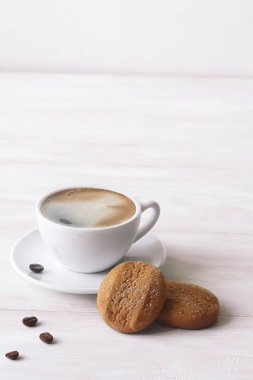 Tereyağlı kahve, pudra şekerli, beyaz ahşap bir masada..