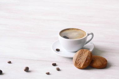 Tereyağlı kahve, pudra şekerli, beyaz ahşap bir masada..