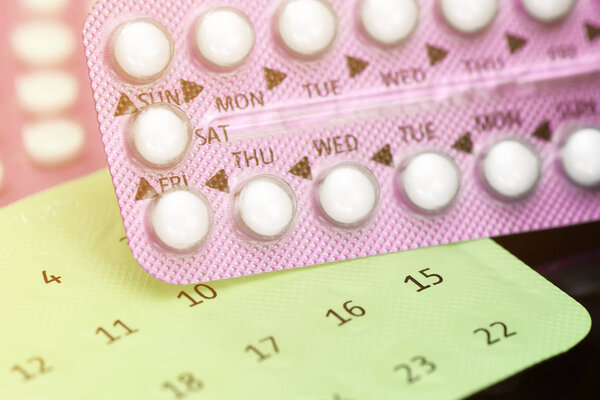 Oral contraceptive pill education concept on dark background.