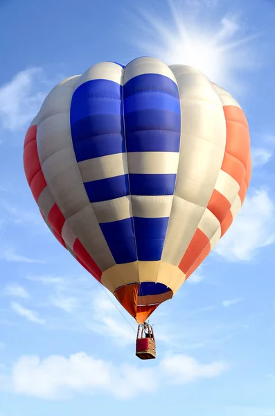 Kleurrijke hete luchtballon over heldere hemel met wolken. — Stockfoto