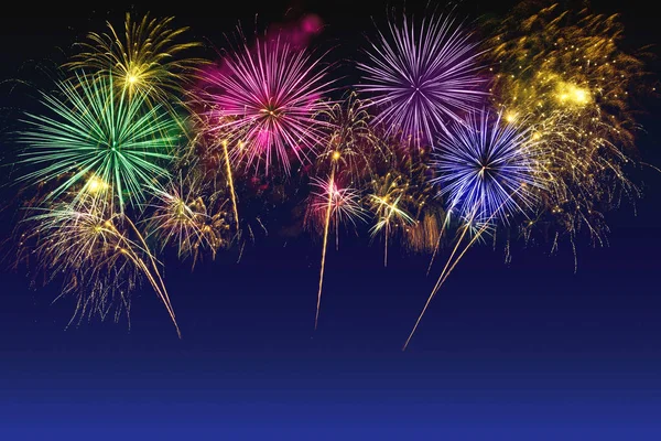 Alacakaranlık gökyüzünde renkli havai fişek kutlaması.