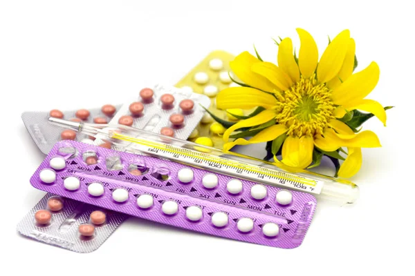 Píldoras anticonceptivas orales, termómetro y flor del sol en ba blanco —  Fotos de Stock