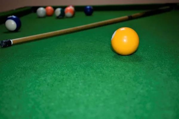 Bilardo masasında ıstaka ve toplar. Yeşil bilardo arka planı