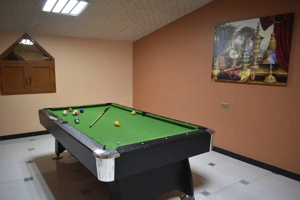 Bilardo masasında ıstaka ve toplar. Yeşil bilardo arka planı