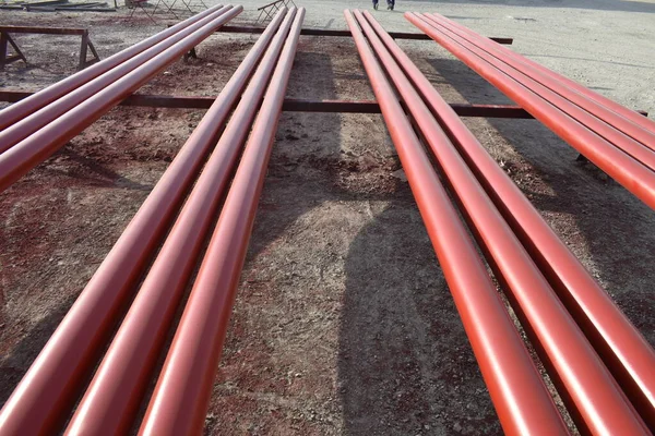 Red steel pipes for fire fighting system and extinguishing water lines in industrial building. Paint shop. Steel pipe painted red color for installation the fire protection system.