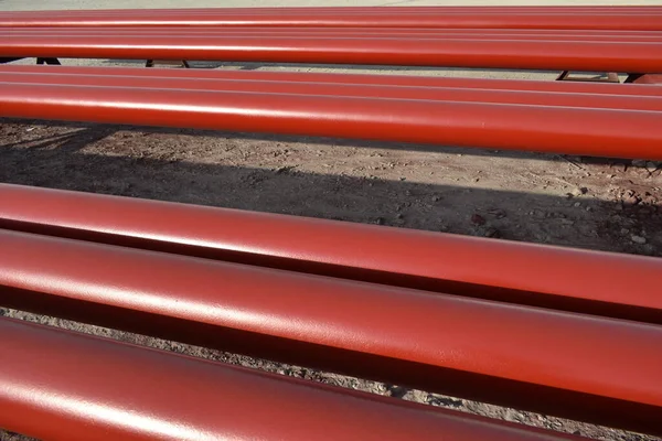 Red steel pipes for fire fighting system and extinguishing water lines in industrial building. Paint shop. Steel pipe painted red color for installation the fire protection system.