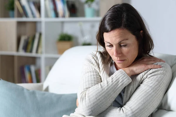 Sorglig Medelålders Kvinna Tittar Ner Deprimerad Sitter Soffan Vardagsrummet Hemma — Stockfoto