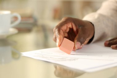 Evdeki bir masada oturan siyah adamın ellerini silen lastik ile yakın plan.