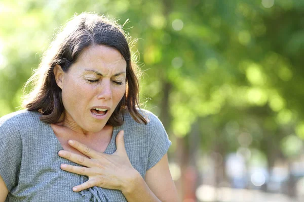 Middelbare Leeftijd Vrouw Piepende Ademhaling Houden Borst Staande Een Park — Stockfoto