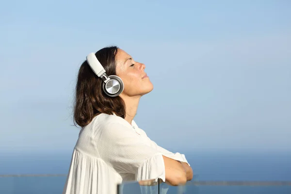 Rahatlamış Yetişkin Bir Kadın Yazın Plajda Kulaklıkla Müzik Dinliyor — Stok fotoğraf