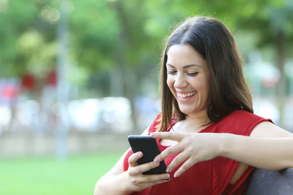 Happy Woman Sititng Bench Park Laughing Checking Smart Phone Content — Stock Photo, Image