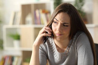 Şüpheli bir kadın akıllı telefondan arıyor. Evdeki oturma odasında oturuyor.