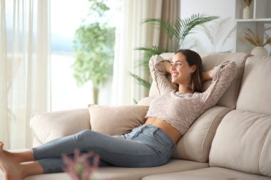 Mutlu kadın şezlongda oturup evdeki pencereden bakıyor.