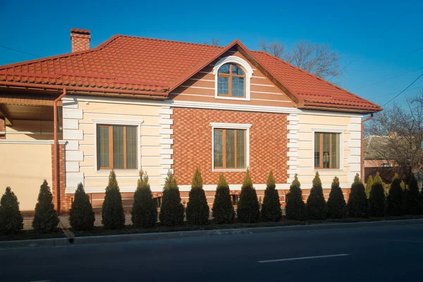 Фасад Дома Вечнозелеными Кустами Перед Ним Синий Фон Неба — стоковое фото