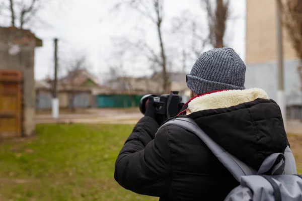 Чоловік Теплій Куртці Шапці Заднім Пакетом Стоїть Назад Камери Фотографує — стокове фото