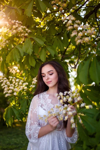 Piękna Nastolatka Białej Sukience Długimi Ciemnymi Włosami Kwitnącym Kasztanowym Drzewie — Zdjęcie stockowe