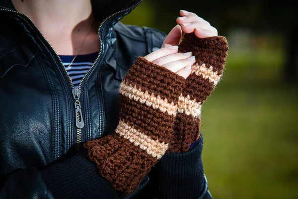 在模糊的背景下 女性的手被编织成褐色条纹手套或腕部暖器 秋季和冬季服装及配件概念 — 图库照片