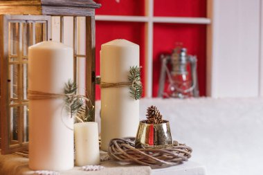 Beyaz mumlar, köknar dalları, koniler ve çelenklerle süslenmiş Noel süsleri. Yeni yıl ve kış tatili konsepti.