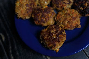 Mavi tabakta et ve havuç pirzolası siyah ahşap arka planda duruyor. Lezzetli ve sağlıksız yemekler. Diyet, beslenme, yeme alışkanlıkları. Metin için yer