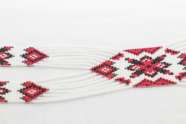 Gyöngyös Etnikai Vörös Fekete Nyaklánc Fehér Szövet Háttér Női Kiegészítők — Stock Fotó