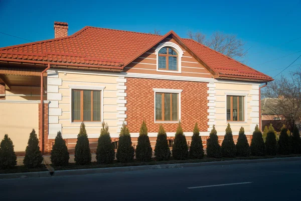 Фасад Дома Вечнозелеными Кустами Перед Ним Синий Фон Неба — стоковое фото