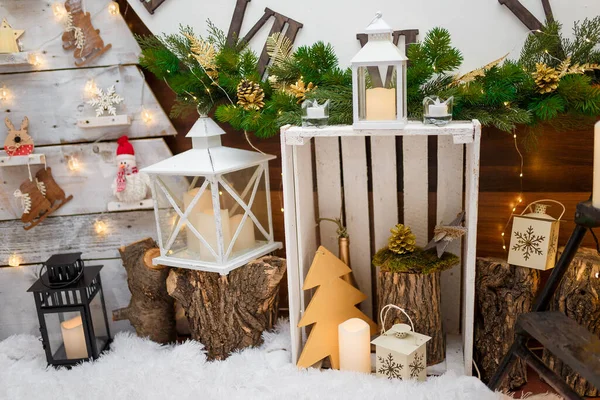 人工雪の上に立つメリークリスマスとハッピーニューイヤーの装飾 白い木製の箱 ろうそく 木製のおもちゃ モミの木の枝や暖かいガーランドライト 冬休みのコンセプト — ストック写真