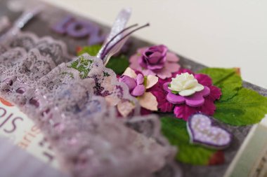 Kağıt dekoratif elementler, çiçekler, kalp, kurdeleler ve dantelli fotoğraf albümü sayfasının yakın plan çekimleri. Boş zaman ve hobi konsepti.