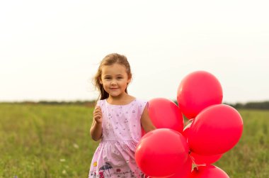kız yaz aylarında doğa kırmızı balon ile çalışır