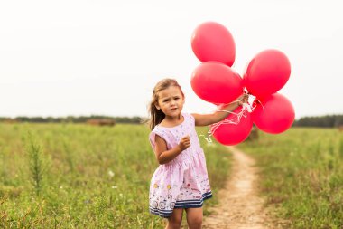 kız yaz aylarında doğa kırmızı balon ile çalışır